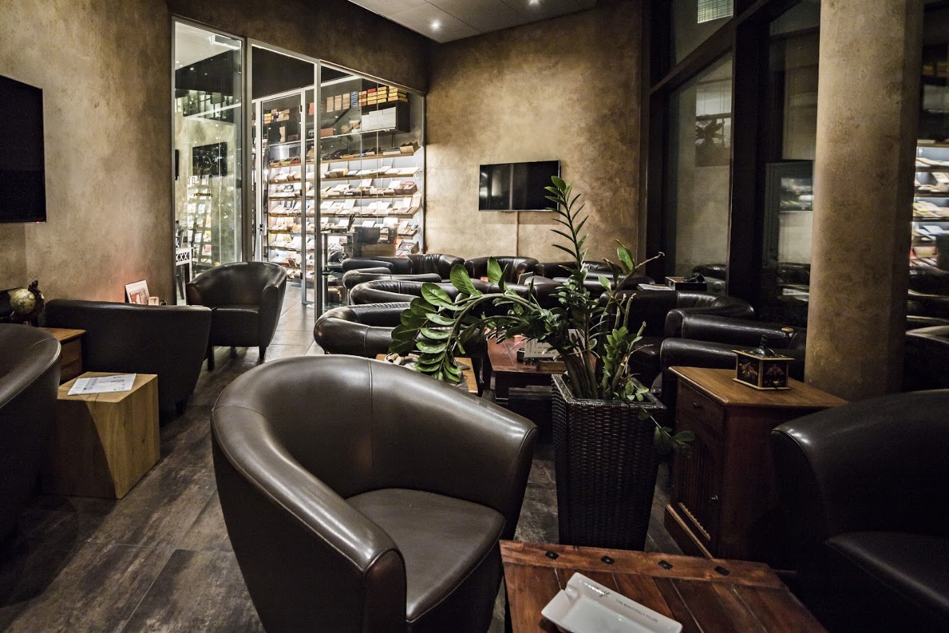 Lederclubsessel im Fumoir mit Blick auf den begehbaren Humidor
